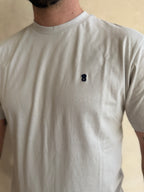 CAMISETA  GRIS CLARITO CON CUELLO REDONDO Y BORDADO MEDUSA
